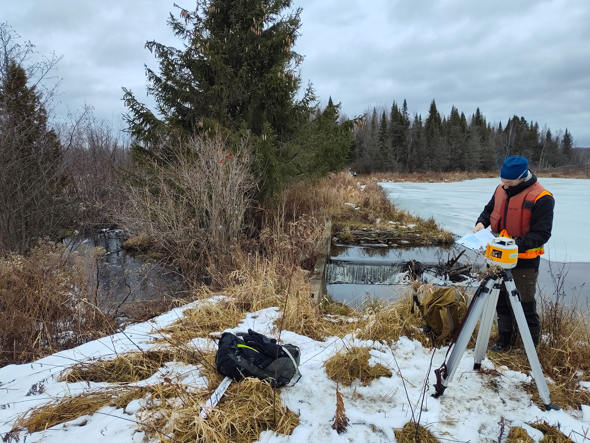 Homme travaillant près d'un ruisseau gelé.