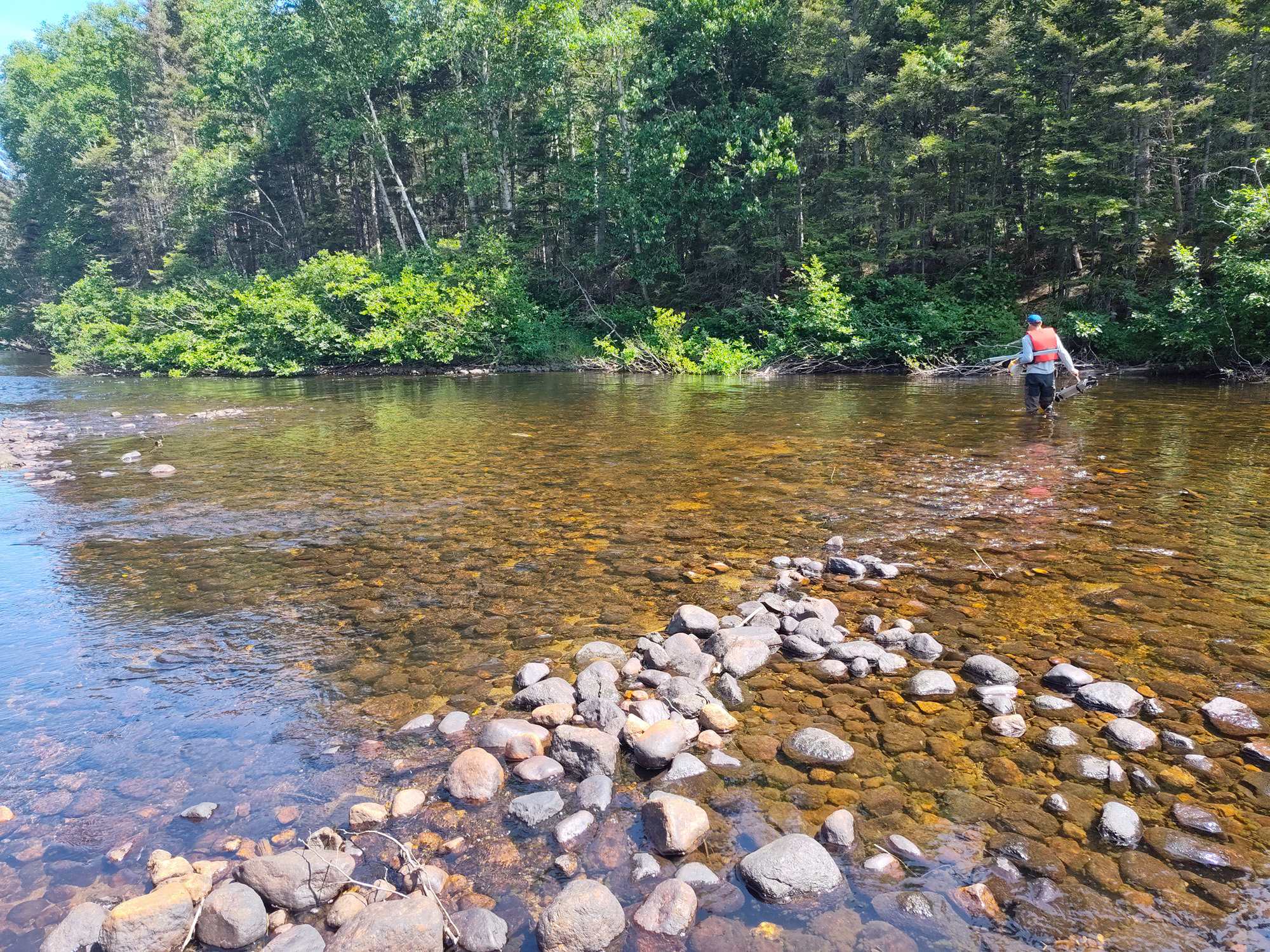 Homme traversant une rivière claire.