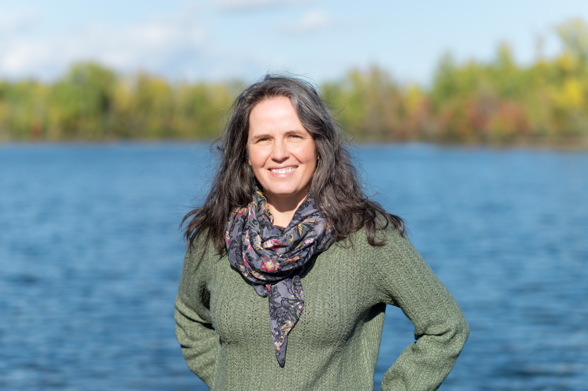 Femme souriante près d'un lac.
