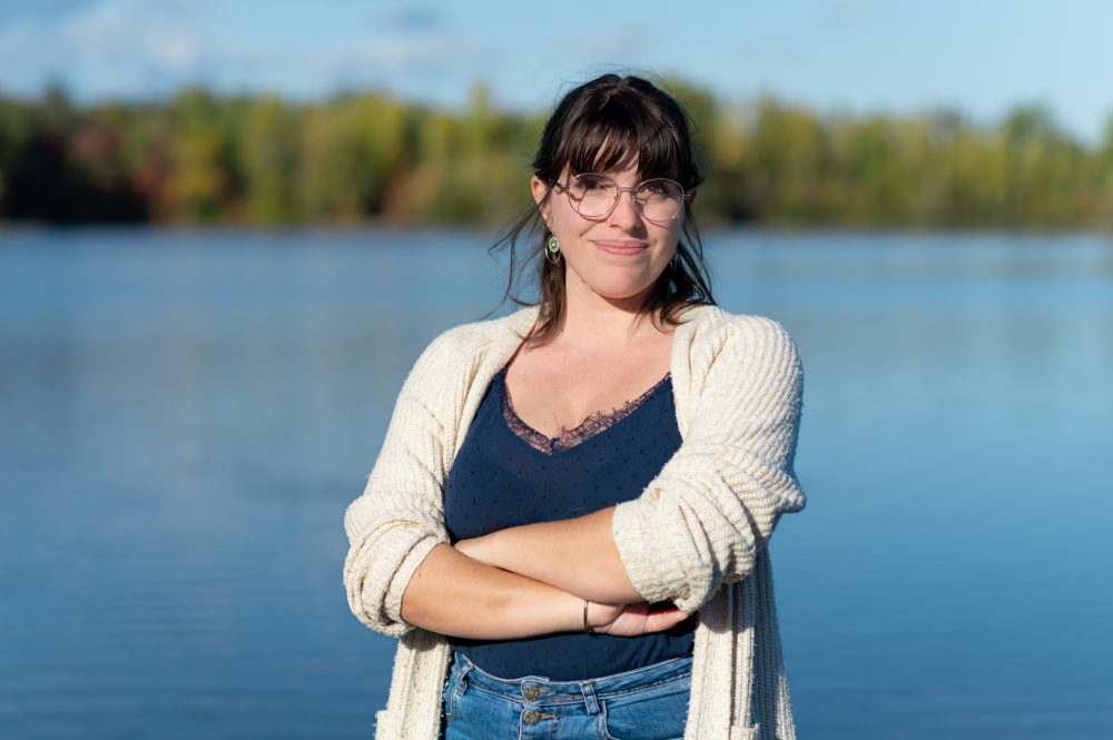 Femme souriante près d'un lac.