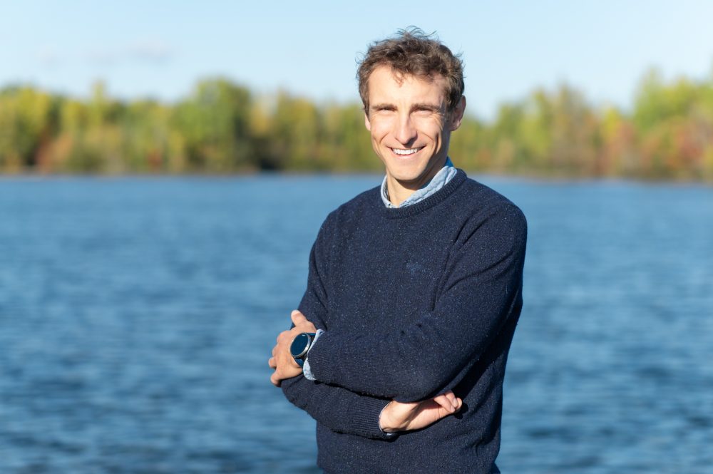 Homme souriant près d'un lac.