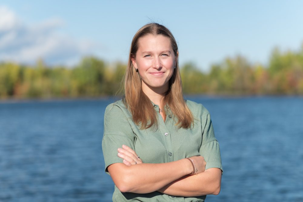Femme souriante près d'un lac.
