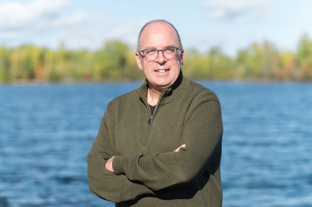 Homme souriant près de l'eau.
